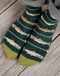 Green socks with fish pattern worn on a wooden floor