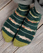 Green socks with fish pattern worn on a wooden floor